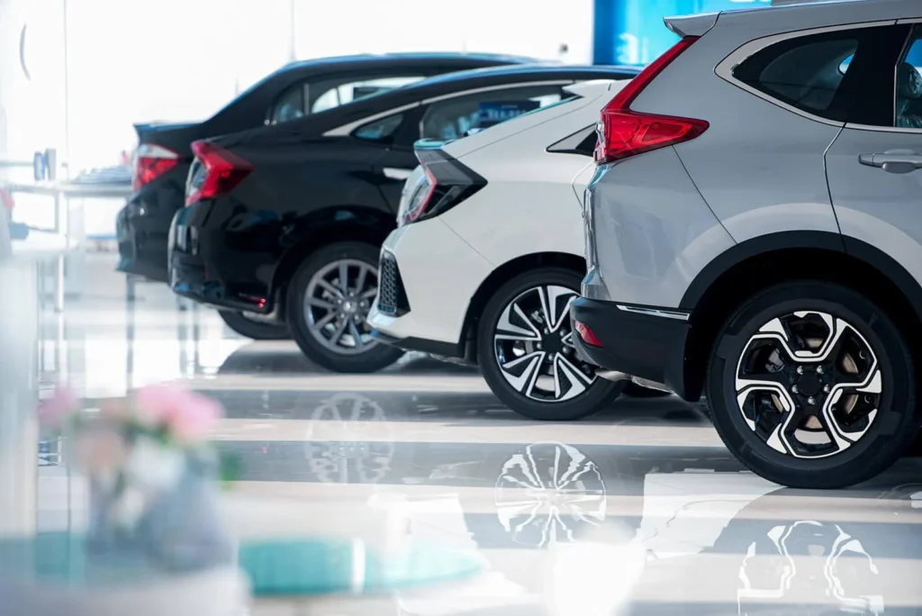 A modern white car parked in a clean, well-lit garage, representing professional car care.