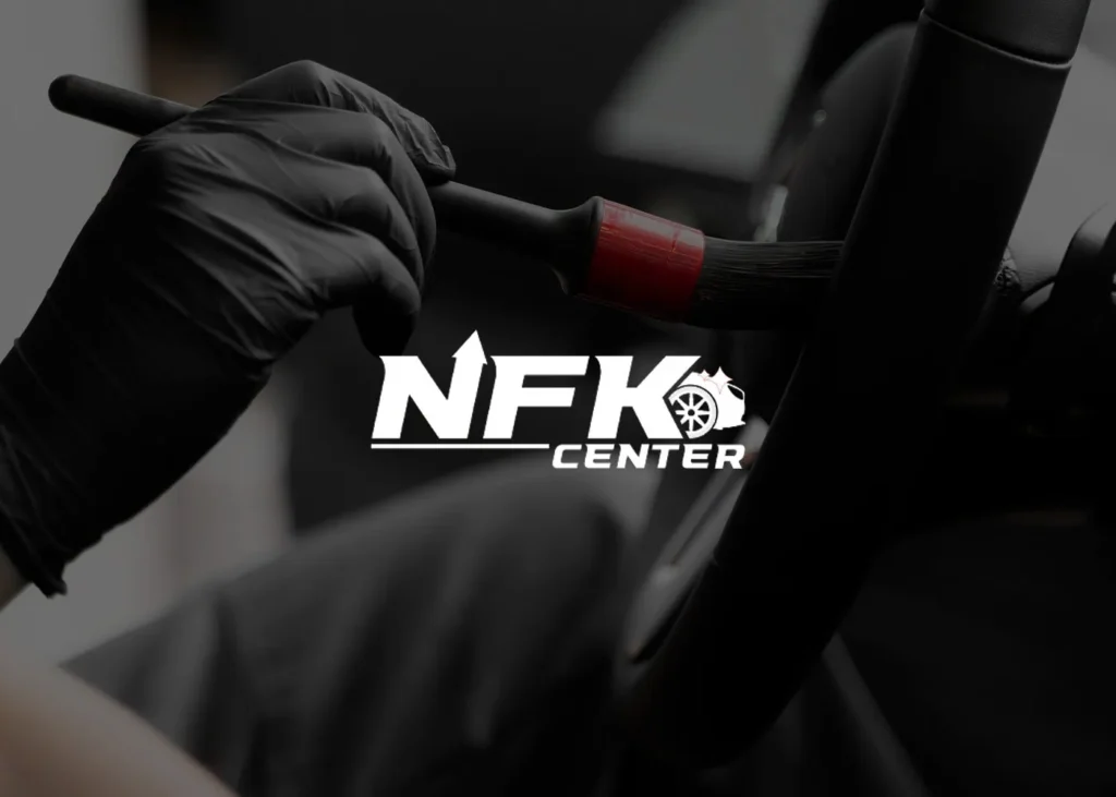 Rød bil i det mørke værksted hos NFK Center Nyborg.